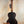 Dark wooden acoustic guitar with neck strap above Kala Solid Spruce Top Tenor Ukulele