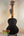 Dark wooden acoustic guitar with neck strap above Kala Solid Spruce Top Tenor Ukulele