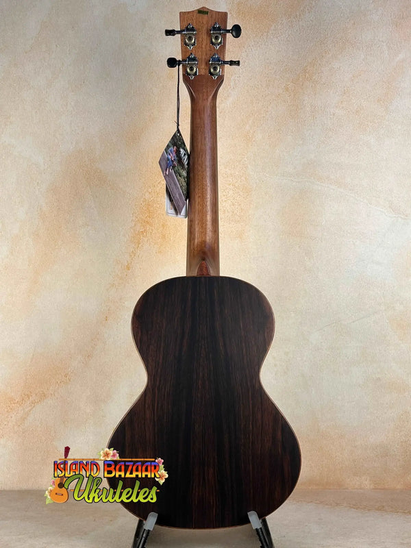 Dark wooden acoustic guitar with neck strap above Kala Solid Spruce Top Tenor Ukulele