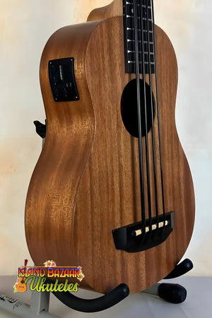 Wooden Kala U-Bass Nomad Acoustic-Electric Bass Ukulele with black hardware on stand