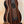 Striped Ebony Acoustic-Electric Bass Ukulele with four strings and a black bridge