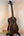 Dark wooden Kala UBASS-EBY-FSRW Striped Ebony Acoustic-Electric Bass Ukulele on black stand