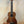 Brown wooden Kala Wanderer U-Bass Ukulele acoustic-electric on a black stand