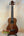 Brown wooden Kala Wanderer U-Bass Ukulele acoustic-electric on a black stand