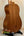 Wooden acoustic guitar on a black stand next to a Kala Wanderer U-Bass Ukulele