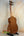Wooden Kala Wanderer U-Bass Ukulele Acoustic-Electric with black tuning pegs on stand