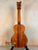 Wooden Kamaka Concert Ukulele HF-2 in solid Hawaiian Koa finish on black stand