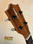 Wooden headstock of Kamaka HP-1 Pineapple Soprano Ukulele with tiger stripe pattern