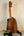 Wooden Kamaka HP-1 Pineapple Soprano Ukulele on black stand with hard case