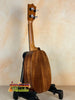 Wooden Kamaka HP-1 Pineapple Soprano Ukulele on black stand with hard case