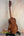 Wooden Kanile’a DK-T D-Hole Tenor Ukulele in Premium Koa on black stand