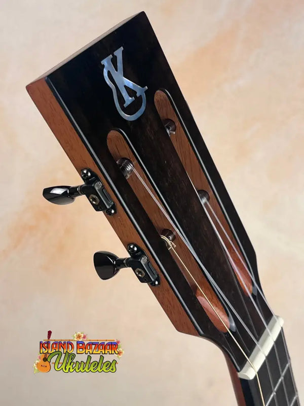 Guitar headstock with black tuning pegs on Kanile’a DK-T D-Hole Tenor Ukulele Premium Koa