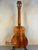 Wooden acoustic guitar showcasing Kanile’a Hawaiian Premium Tenor Ukulele Curly Koa design