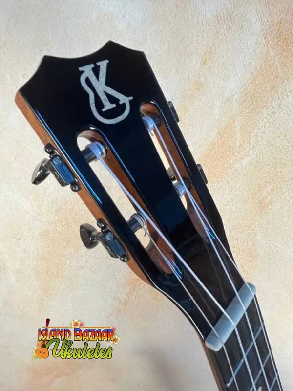 Black guitar headstock with silver tuning pegs on Kanile’a Hawaiian Premium Tenor Ukulele