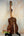 Wooden acoustic guitar with dark walnut patterns on a stand, Kanile’a HNS-T-PREM Tenor
