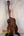 Wooden acoustic guitar on a black stand next to Kanile’a Honus Tenor Ukulele