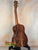 Wooden acoustic guitar on black stand featuring Kanile’a ISL-T Hawaiian Islands Tenor Ukulele