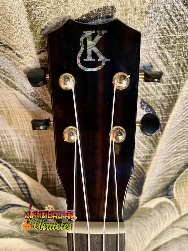 Guitar headstock with KC logo and tuning pegs on Kanile’a ISL-T Tenor Ukulele