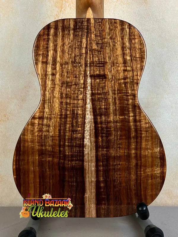 Acoustic guitar showcasing figured Koa wood back of Kanile’a K-1 Deluxe Tenor Ukulele