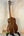Wooden Kanile’a K-1 Tenor Ukulele with dark grain on black stand, deluxe koa wood design