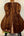 Acoustic guitar with dark wood back on stand showcasing Kanile’a K-1 Tenor Ukulele Deluxe Koa Wood