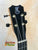 Black ukulele headstock with silver tuning pegs and Kanile’a K-1 Tenor logo