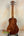 Wooden Kanile’a K-2 Deluxe Concert Ukulele with Hawaiian Koa Body on black stand