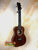 Wooden Kanilea K3-T Tenor Koa Ukulele with dark brown finish and maple rosette