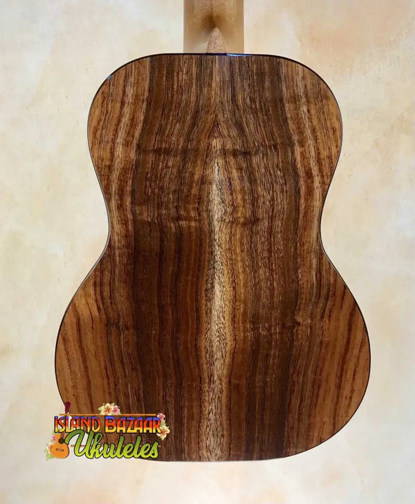 Wooden acoustic guitar back panel of Kanilea K3-T Tenor Koa with rich grain patterns