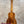 A kanileʻa koa core concert ukulele with a warm brown finish and intricate wood grain patterns in a deluxe gig bag