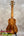 A kanileʻa koa core concert ukulele with a warm brown finish and intricate wood grain patterns in a deluxe gig bag