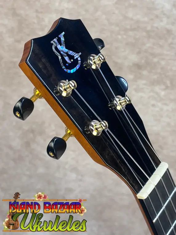 Black kanileʻa honus tenor ukulele headstock with blue white logo gold tuning pegs and black knobs