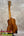 Kanileʻa koa core concert ukulele polished mahogany with golden tuning pegs on black stand for kanileʻa honus tenor fans