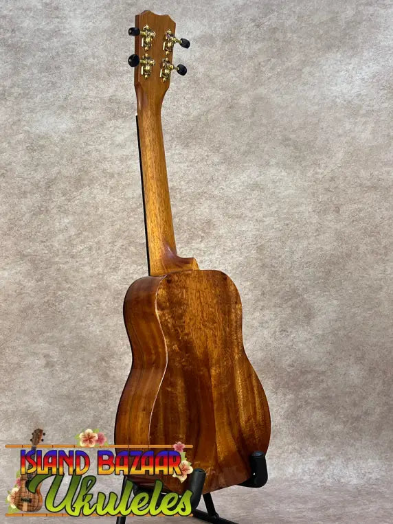 Kanileʻa koa core concert ukulele polished mahogany with golden tuning pegs on black stand for kanileʻa honus tenor fans