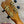 Wooden kanileʻa honus tenor ukulele headstock with gold tuning machines and black pegs on koa concert model