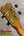 Wooden kanileʻa honus tenor ukulele headstock with gold tuning machines and black pegs on koa concert model