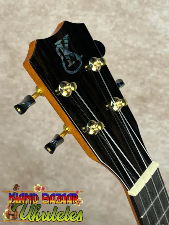 Ukulele headstock with four tuning pegs and mother-of-pearl inlay on Kanileʻa KPA-C master concert ukulele