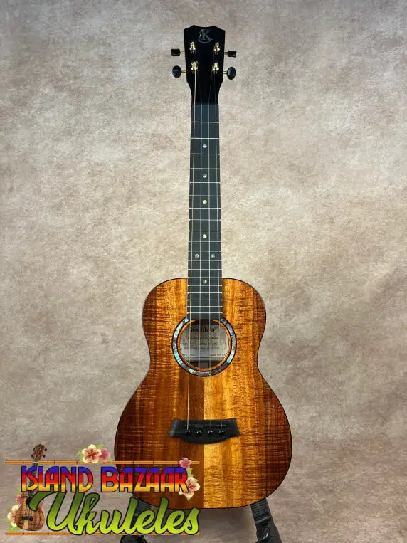 Glossy dark orange-brown Kanile’a KPA Pro Tenor Koa Ukulele with black fretboard and light rosette