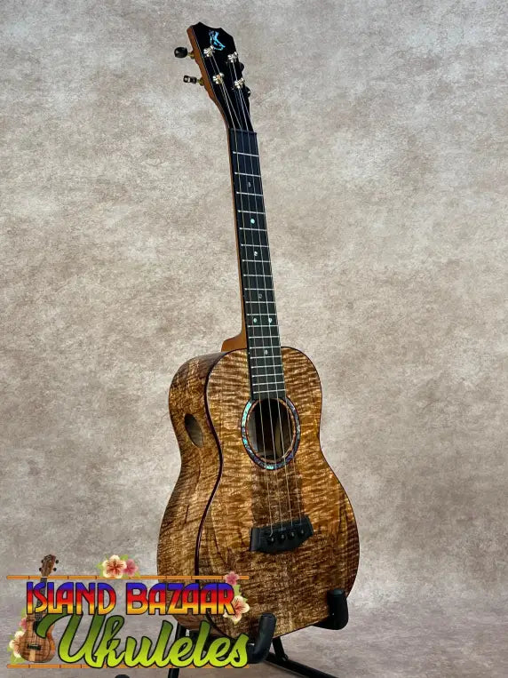 A kanilea kpa pro tenor ukulele with a warm golden-brown solid mango wood body and black fretboard in deluxe gig bag