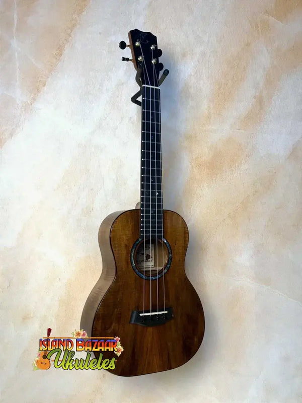 Brown wooden Kanilea KPA-T Prem Tenor Ukulele with black tuning pegs and strings