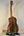Wooden acoustic guitar on a black stand with Kanilea KPA-T Tenor Ukulele Hawaiian Koa