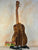 Wooden acoustic guitar on a black stand with Kanilea KPA-T Tenor Ukulele Hawaiian Koa