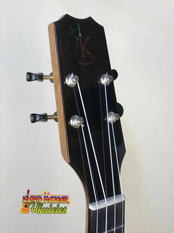 Guitar headstock with black finish and silver pegs on Kanile’a P-1 Pineapple Tenor Ukulele