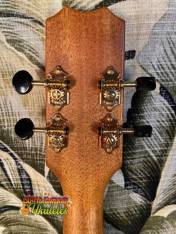 Guitar headstock with gold tuning machines on a Kanile’a Pineapple Hawaiian Koa Tenor Ukulele