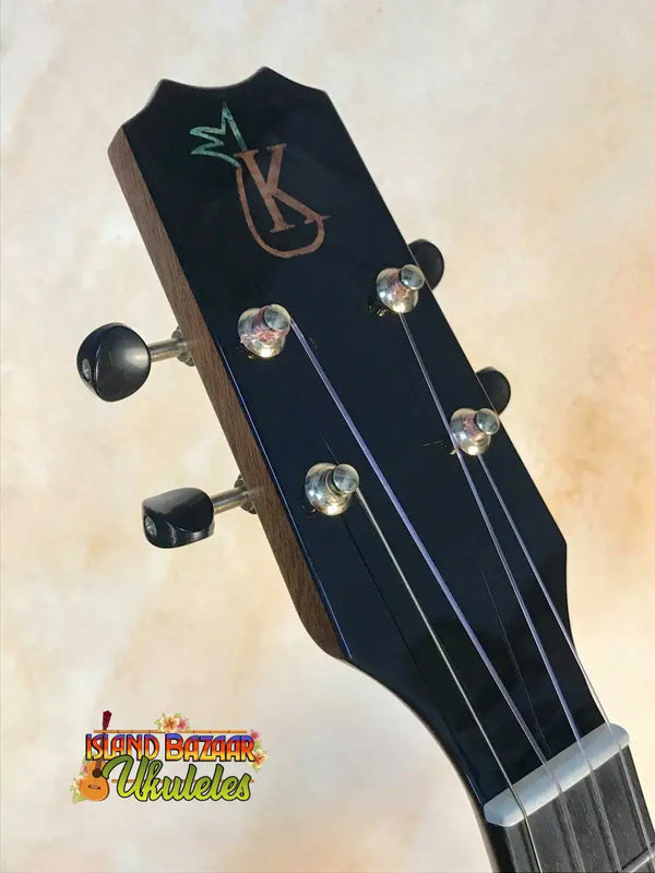 Guitar headstock with chrome tuning pegs and custom logo on Kanile’a Pineapple Tenor Ukulele