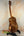 Brown wooden Kanile’a Tenor D-1 Ukulele on a stand with Deluxe Gig Bag