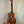 Wooden ukulele with natural finish on stand; KoAloha KCM-00 Concert, Solid Hawaiian Koa