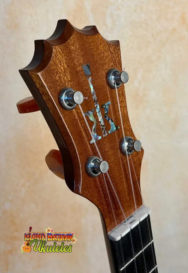 Guitar headstock with decorative inlay and tuning pegs on KoAloha KCM-00 Concert Ukulele