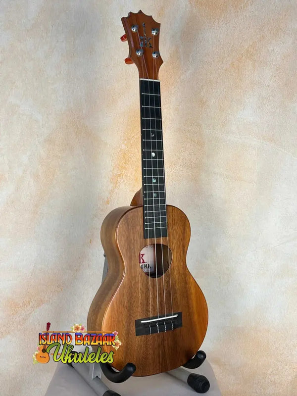 Wooden KoAloha KCM-10 Concert Ukulele in Solid Hawaiian Koa resting on a stand