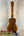 Wooden KoAloha KCM-10 Concert Ukulele in Solid Hawaiian Koa on black display stand